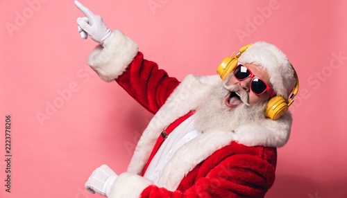 Cool Santa Claus Dancing with Yellow Headphones and Red Sunglasses on Pink Background Concept