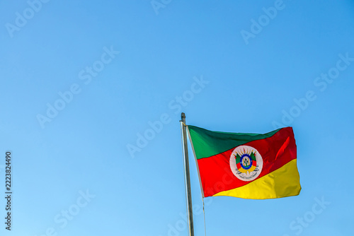 Rio Grande do Sul state flag waves against a clear blue sky, Brazil