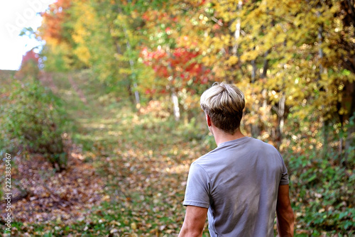 Teen Boy Walking on Forest Trail By Fall Trees