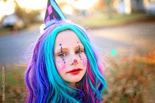 Cute Little Child in Clown Costume Trick-or-Treating on Halloween.