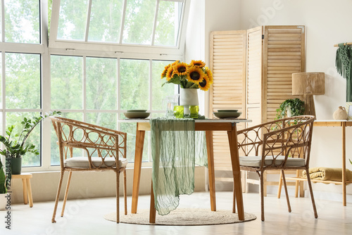 Home interior design and lifestyle, dining table with sunflowers and rattan c...