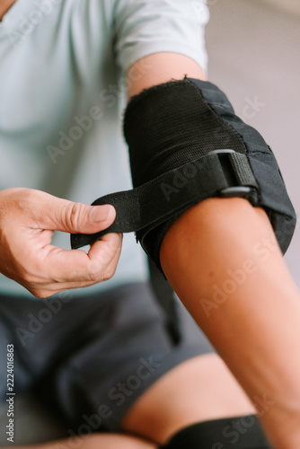 Person securing protective elbow pad for inline skating activity
