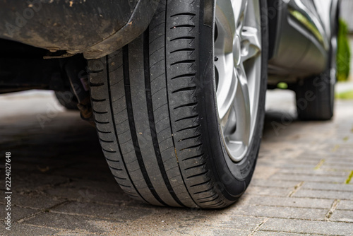 Close-up of car tire tread and wheel parked outside