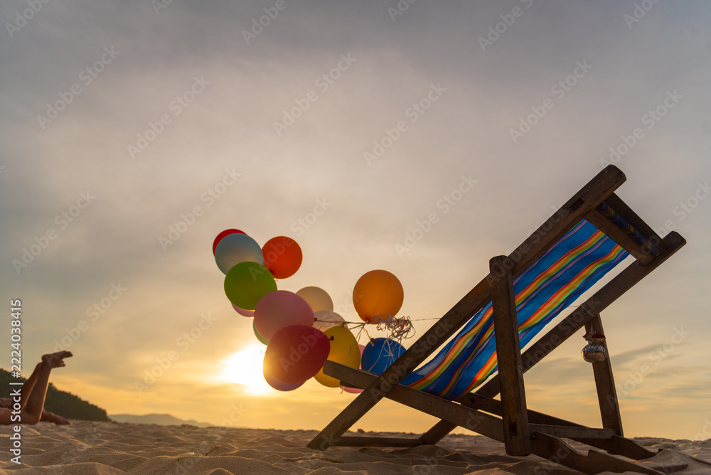 Fototapeta premium Sunset Colourful balloon gold sand beach background golden sky childhood playground. Hand holding balloons sunlight freedom dusk background festival design element. Hot air balloon outdoor summer