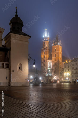 Krakow, Poland, Main Market square, St Mary's church and Cloth Hall on a foggy night