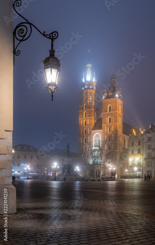 Krakow, Poland, Main Market square, St Mary's church and Cloth Hall on a foggy night
