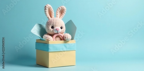 Gift box with knitted bunny rattle and teether Pastel blue backdrop , present, teether