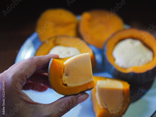 Pumpkin custard sits on a plate; it looks appetizing and delicious. I made this Thai dessert myself, using a mixture of duck eggs, coconut sugar, and fresh milk, which I then steamed.