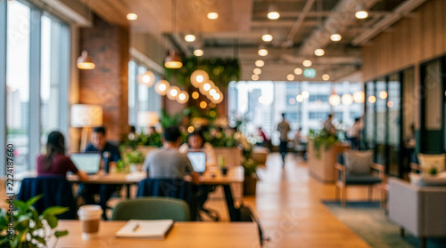 Blurred modern coworking space with people working on laptops, bokeh