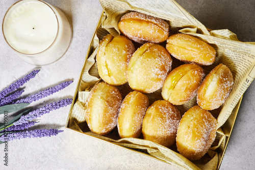 Sugar-Coated Jam Filled Doughnuts In Gift Box Styled On Newspaper Liner For Breakfast Treat