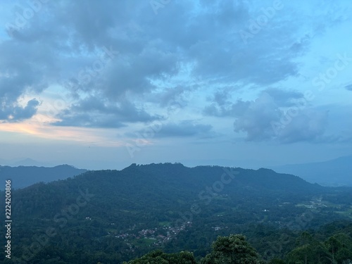 sunset view from the top of the hill with clouds over the mountains