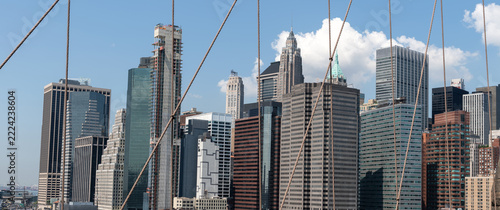 2019 New York City, USA; Panoramic view of Financial District skyscrapers in Lower Manhattan framed by Brooklyn Bridge steel cables