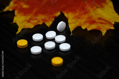 Pills and maple leaves. Concept of nutrition supplements, antidepressants, vitamins for immunity in autumn flu season