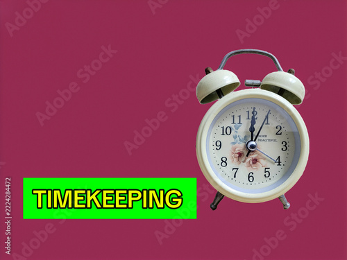 Retro Alarm Clock with Timekeeping Text Concept Isolated on Burgundy Background for Schedule and Time Management