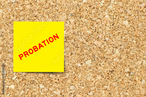 Yellow note paper with word probation on cork board background with copy space