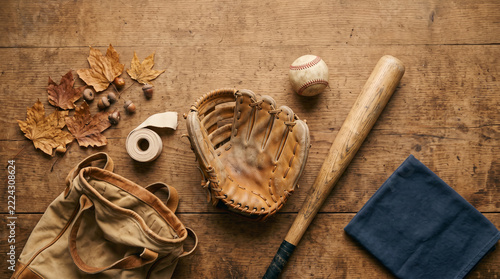 top view of vintage baseball gear with leather glove and wooden bat