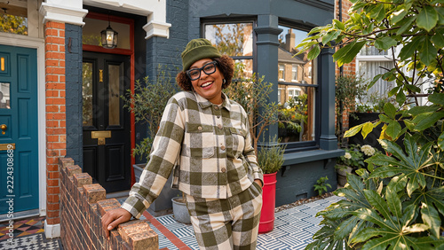 Stylish Woman Smiling Outside Colorful Urban Home