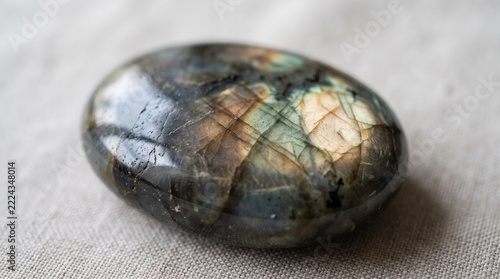 Polished labradorite gemstone with iridescent surface texture on a