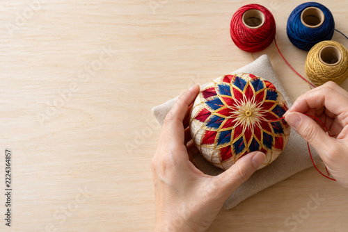 Japanese hands making traditional colorful temari ball