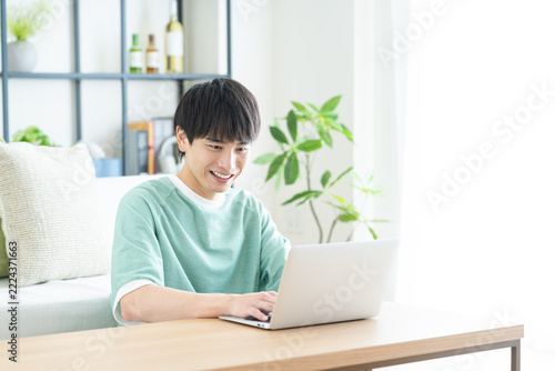 リビングでパソコンを使う若い男性