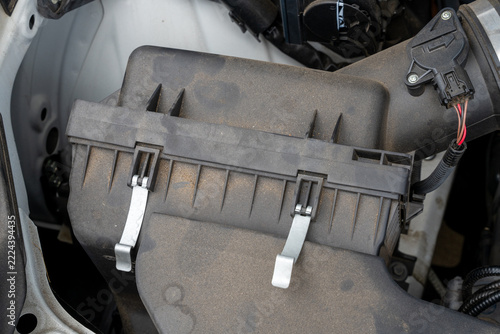 Dirty air intake housing in car engine compartment