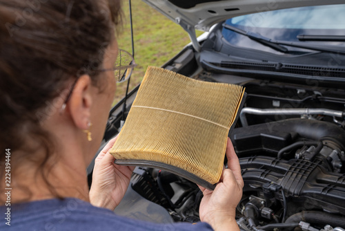 Woman holds dirty car air filter