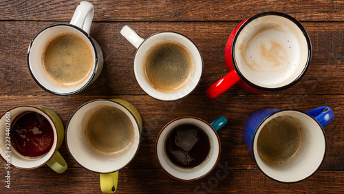 ceramic mugs with unfinished coffee on a wooden background, top view, long banner