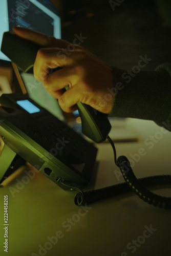 Scammer Making Telephone Call Among Computer Screens. Telephone Fraud Concept.