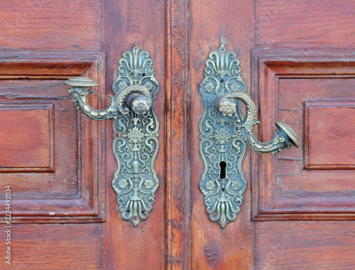 Antique‑style bronze door handles on a wooden door