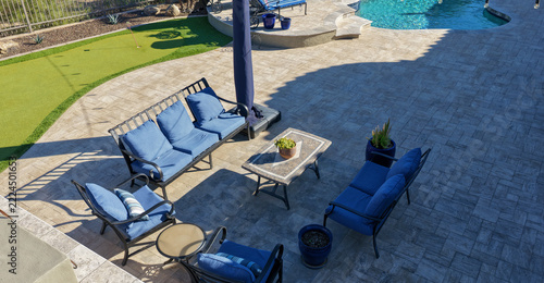 4K aerial view of a luxury Arizona desert landscaped backyard featuring a saltwater swimming pool, spa, outdoor BBQ kitchen, fireplace, putting green and low-maintenance landscaping.