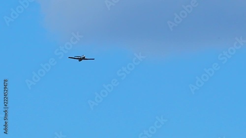 Small airplane flying over blue sky.