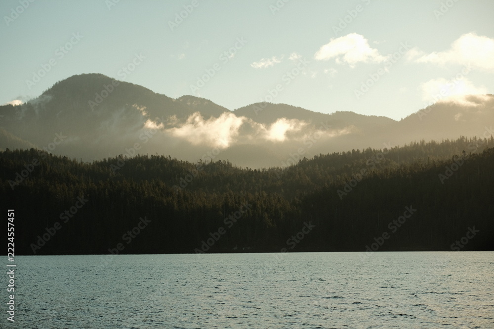 Naklejka premium Layered Misty Mountains Over Water