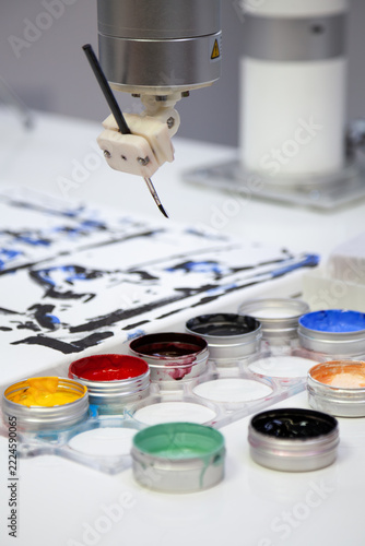A robotic arm paints picture using brush and paints