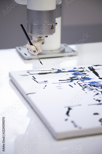 A robot painting with paints and a brush
