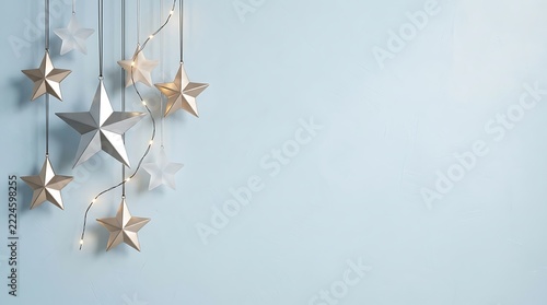 Hanging christmas stars with fairy lights on light blue background ornament decoration celebration december tradition greeting backdrop vertical