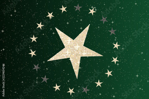 Golden glitter stars arranged in circular pattern on dark green holiday luxury festive background.
