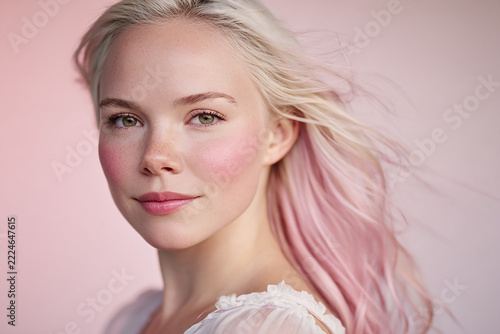 Close-up portrait of a woman with flowing pink hair, soft studio lighting and a refined beauty aesthetic for commercial design and branding.