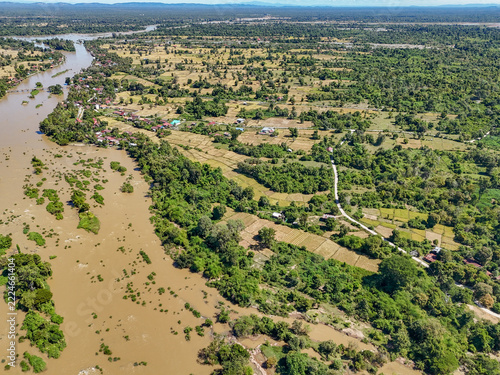 Aerial view of the lush landscape of Don Khon island along the Mekong River, featuring dense tropical vegetation, rural farmland, and winding riverbanks in Khong, Champasak Province, Laos.