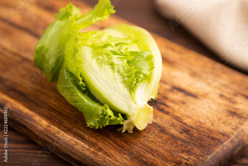 Lettuce on wooden cutting board on brown wooden. side view, close up, selective focus