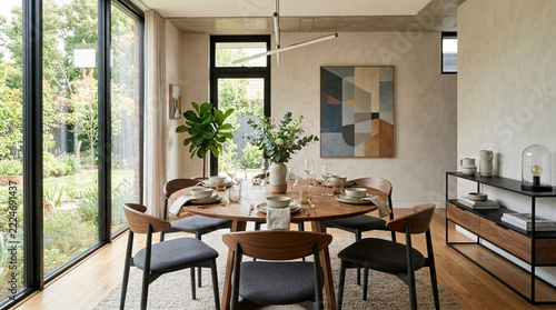 Modern Dining Room with Round Table Chairs Large Windows and Abstract Art Cozy Interior Design
