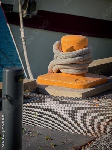 Orange boat cleat with mooring rope on dock