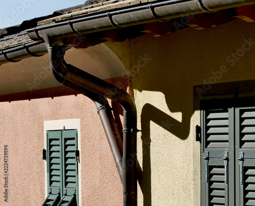 Double gutter downpipe on the slate roof of a country house.