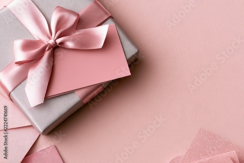 Shiny gift box and matching card with ribbon bow, soft pink and silver tones, flat lay background ready for design templates