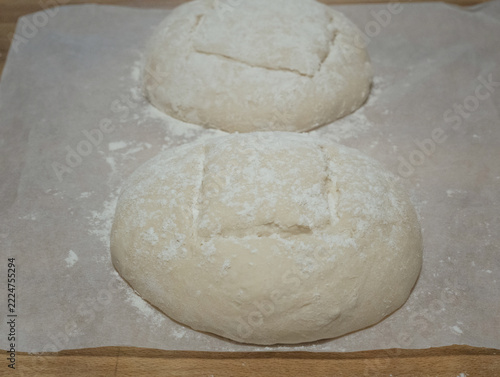 Close-up of raw sourdough bread dough loaves scored on baking paper
