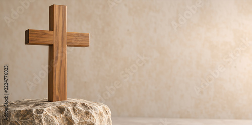 Wooden cross standing on a rough stone pedestal. Christian symbol of faith against textured beige wall. Copy space for text