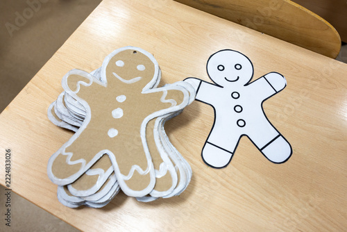 Christmas preparation, a lot of handmade ornated cardboard gingerbread mans on wooden table, eco friendly holiday