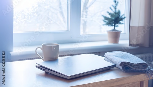 Generic Closed Laptop Positioned at the Edge of a Desk Facing a Bright Winter Window, Minimal Digital Workspace and Seasonal Light Concept