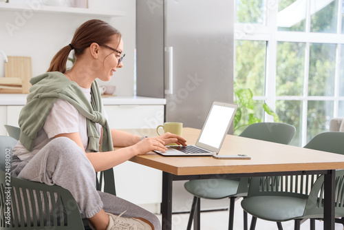 Remote work and digital nomad lifestyle, young woman working on a laptop at h...