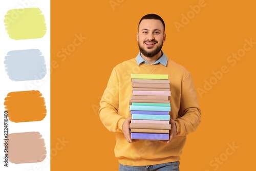 Education and lifelong learning, smiling man holding a stack of books for aca...