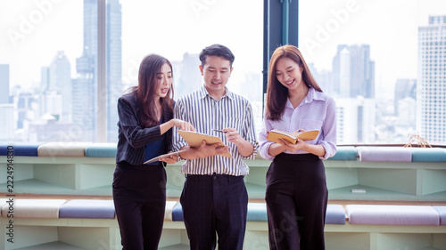 Asian Business Team Collaborating and Discussing Ideas in a Modern Office with City View